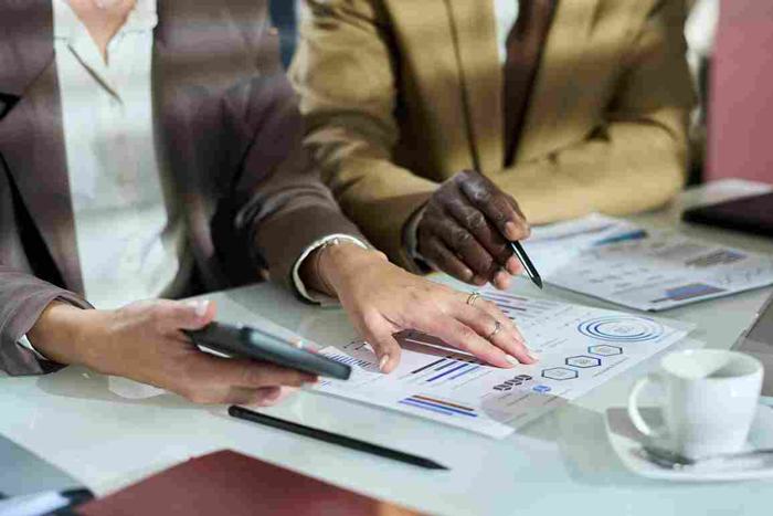 Gestão de contratos na administração pública: duas pessoas analisam relatórios e documentos, representando transparência, controle de prazos e eficiência na Nova Lei de Licitações.